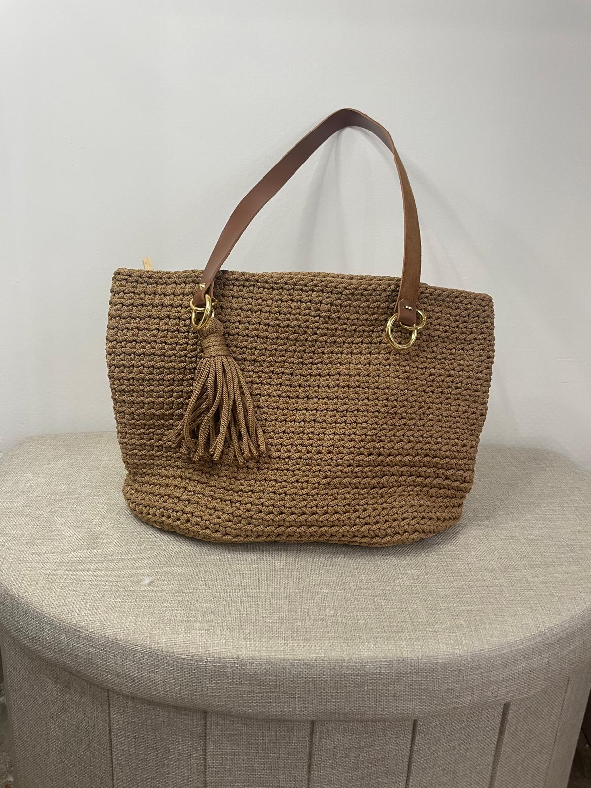 Sac à main en crochet de couleur camel beige, orné d'un gros pompon assorti sur le côté. Anse unique pour porté épaule avec anneaux métalliques dorés. Création artisanale française Vanda, style bohème chic.