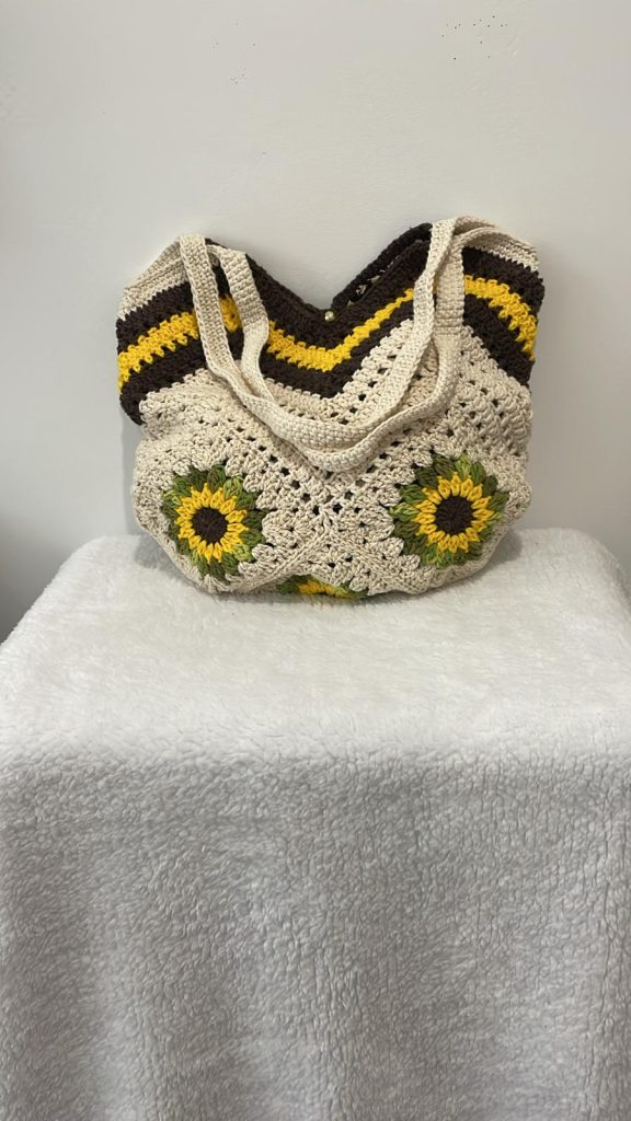 Tote bag au crochet 100% coton écru avec tournesols en relief et bordure chevrons jaune et brun chocolat, fait main par Vanda dans son atelier d'Albi – pièce unique, doublure intérieure, fermeture bouton pression dorée, personnalisable sur commande