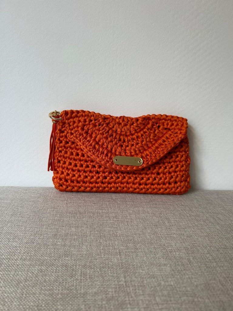 Clutch orange au crochet fait main avec rabat arrondi, plaque dorée et frange assortie, création artisanale française VANDA