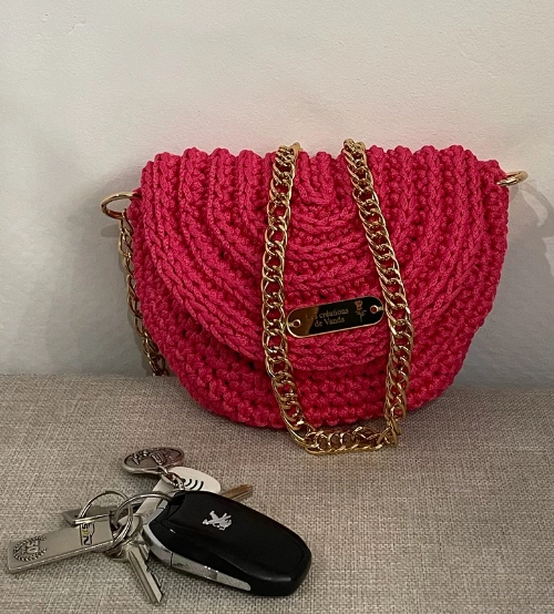 Sac bandoulière rose vif réalisé au crochet avec une chaîne dorée, création artisanale de Vanda.